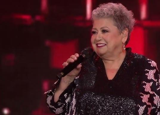 Ewa Bem w studiu nagraniowym, analizująca nuty, otoczona instrumentami.
