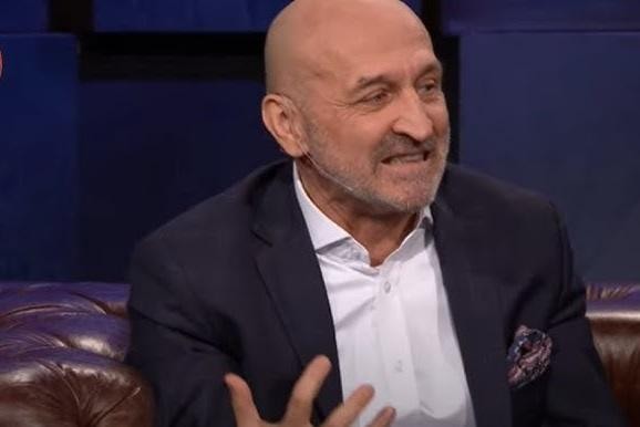 Kazimierz Marcinkiewicz podczas rozmowy lub chwili refleksji w nowoczesnym, profesjonalnym otoczeniu.