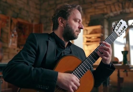 Dłonie Marcina Dylli w akcji podczas gry na gitarze klasycznej, skupienie na technice i detalu.