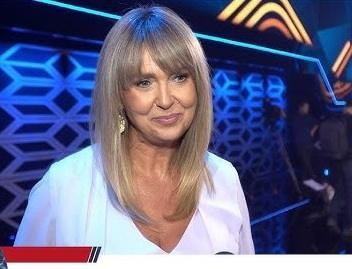 Ewa Wachowicz demonstruje przepis kulinarny w przytulnej kuchni, emanując pasją i entuzjazmem.