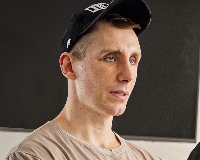 Michał Owczarzak (Owca WK) wykonujący intensywny trening siłowy w siłowni, demonstrujący siłę i determinację.
