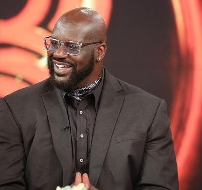 Shaquille O'Neal w akcji na boisku NBA, w stroju Los Angeles Lakers, prezentujący swoją dominującą siłę i atletyzm.