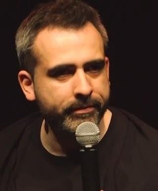 Abelard Giza podczas występu stand-upowego na scenie.