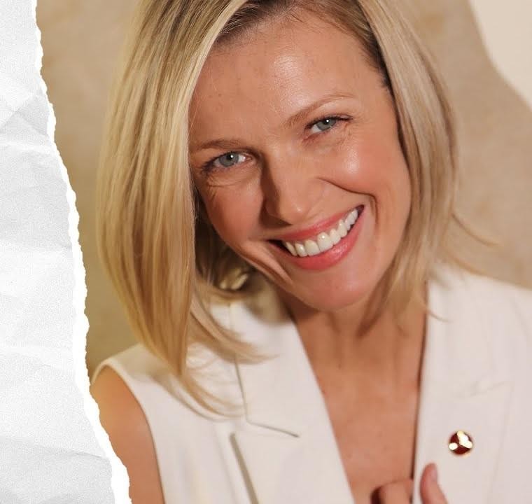 Magda Mołek prowadzi wywiad w studiu telewizyjnym, emanując charyzmą i profesjonalizmem.