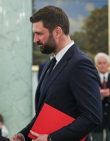 Nikodem Rachoń podczas pracy w gabinecie, analizujący dokumenty związane z polityką międzynarodową.